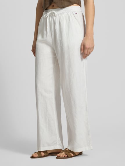 Vrouwenmodel draagt Weite Hose aus Leinen-Mix mit Tunnelzug van Tommy Jeans, witte two tone loose fit met logostiksel, linnenmix, zijzakken, opgestikte achterzakken, voorkant detailopname van de benen