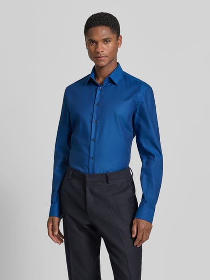 Männermodel trägt Slim Fit Business-Hemd mit Kentkragen von Jake*s in Blau, Reine Baumwolle, Knopfleiste, Sportmanschetten, abgerundeter Saum, Rückenlänge 79 cm, Schulterbreite 48 cm, Ärmellänge 65 cm, Ganzkörperansicht von vorne.