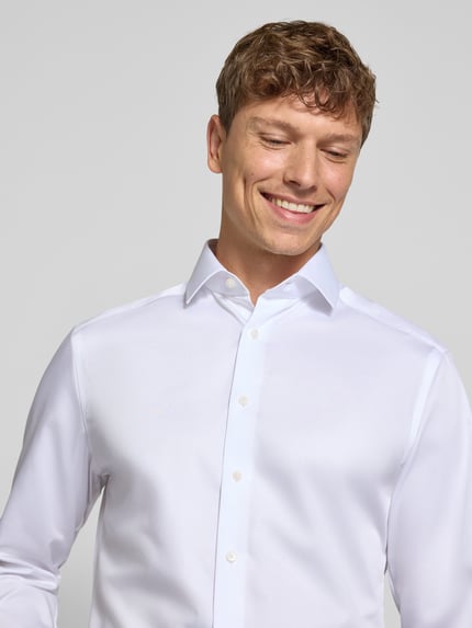 Männermodel trägt weißes Modern Fit Businesshemd aus reiner Baumwolle Modell 'Global Kent' von OLYMP, Nahaufnahme Oberkörper, Herren Businesshemd von OLYMP.