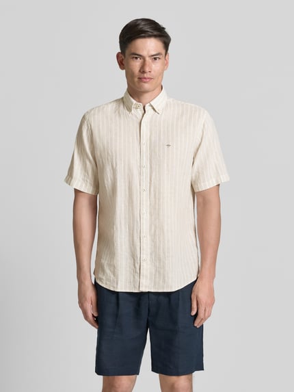 Männermodel trägt Regular Fit Freizeithemd mit Button-Down-Kragen von Fynch-Hatton im Baumwolle-Leinen-Mix, Logo-Stitching, Knopfleiste, Beige mit feiner Struktur, Ganzkörperansicht von vorne, Rückenlänge 76 cm, Schulterbreite 45 cm, Ärmellänge 26 cm.