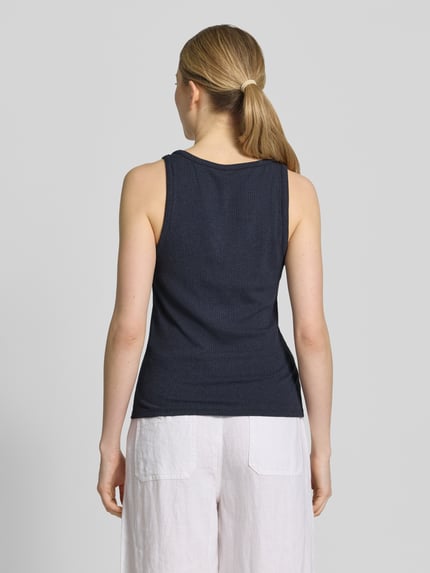 Frauenmodel trägt Regular Fit Tank Top aus Viskose-Mix Modell 'KIKI' von Vero Moda, unifarben, Ripp-Textur, Ganzkörperansicht Rückansicht.