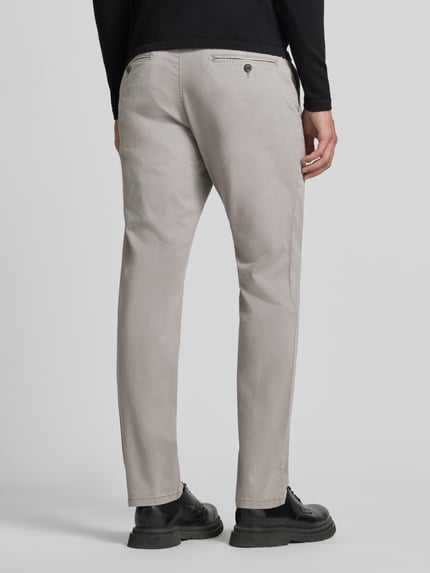 Męski model nosi Hose mit Gesäßtaschen von Christian Berg Men, mieszanka bawełny i elastanu, krój slim fit, wpuszczane kieszenie, jasnoszary, szerokość w rozmiarze 50: 45 cm, długość wewnętrzna nogawki w rozmiarze 50: 80 cm, widok całej sylwetki od tyłu.