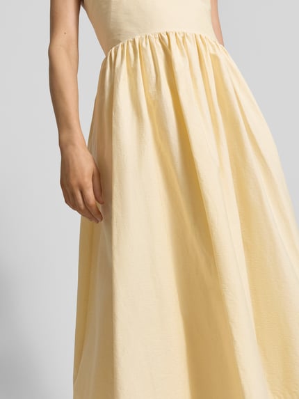 Frauenmodel trägt Midikleid mit Eingrifftaschen Modell 'COVER' von SUNCOO PARIS aus Baumwoll-Mix, A-Linie, Nahaufnahme Oberkörper.