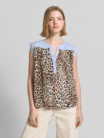 Vrouwenmodel draagt Relaxed Fit Bluse aus reiner Viskose mit Allover-Animal-Print van Emily Van den Bergh, tuniekhals, mouwloos, beige en blauwe tinten, viscose materiaal, voorkant volledig zichtbaar, bovenlichaam close-up.
