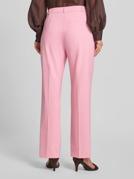 Frauenmodel trägt Stoffhose aus Viskose-Mix mit Gesäßleistentasche von Comma in Rosa, glatte Oberfläche, Bügelfalten, Ganzkörperansicht Rückansicht. Damen Stoffhose, Viskose-Mix mit Stretch-Anteil, Straight Fit, Haken- und Reißverschluss, Französische Eingrifftaschen, Bundweite bei Größe 36: 32 cm, Innenbeinlänge bei Größe 36: 76 cm.