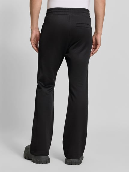 Męski model nosi Flared Fit Hose aus Baumwoll-Mix od Diesel, czarny Materiał skóropodobny, Kieszeń z tyłu, elastyczny pas, mieszanka bawełny, Długość wewnętrzna nogawki w rozmiarze M 76 cm, Szerokość w rozmiarze M 39 cm, Ganzkörperansicht Rückansicht