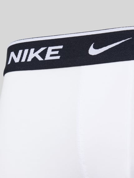 Männermodel trägt Trunks aus Baumwoll-Mix Modell 'ESSENTIAL' von Nike, elastischer Logo-Bund, Nahaufnahme Oberkörper.