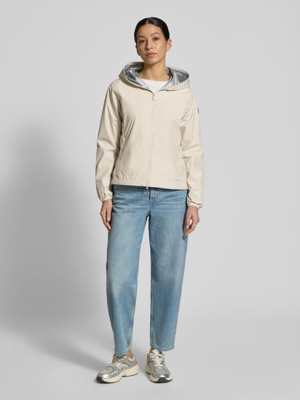 Männermodel trägt Regular Fit Jacke mit Zweiwegereißverschluss Modell 'Stella' von SAVE THE DUCK, beżowy kolor, krój regular fit, zamek dwustronny, kieszenie na zamek, długość pleców w rozmiarze S: 60 cm, szerokość ramion w rozmiarze S: 42 cm, szerokość klatki piersiowej w rozmiarze S: 52 cm, długość rękawa w rozmiarze S: 64 cm, pełny widok z przodu