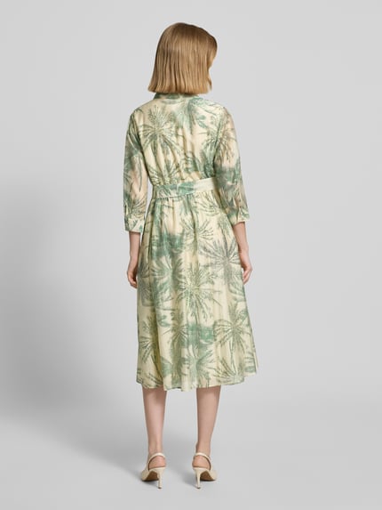 Frauenmodel trägt Figurumschmeichelndes Freizeitkleid aus Lyocell-Mix von s.Oliver BLACK LABEL mit Florales-Allover-Muster, Midi-Länge, V-Ausschnitt, Knopfleiste, Taillengürtel, 3/4-Arm, Materialverarbeitung: Popeline, Material: Viskose-Mix in zarten Grüntönen, Ganzkörperansicht Rückansicht.