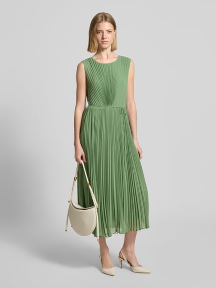 Frauenmodel trägt Regular Fit Kleid mit Plissee von s.Oliver BLACK LABEL, Optik: Unifarben, Midi-Länge, Rundhals-Ausschnitt, Nahtreißverschluss, Bindeband, Ärmelform: Ohne, Materialverarbeitung: Plissee, Ganzkörperansicht von vorne.