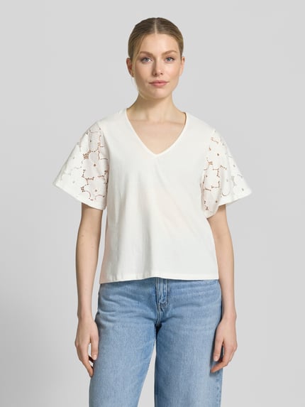 Vrouwenmodel draagt Regular Fit Blusenshirt uit puur katoen model 'VILLA' van Vero Moda, look: effen, met kant, V-hals, korte mouw, jersey materiaalverwerking, dames, voorkant opname bovenlichaam.