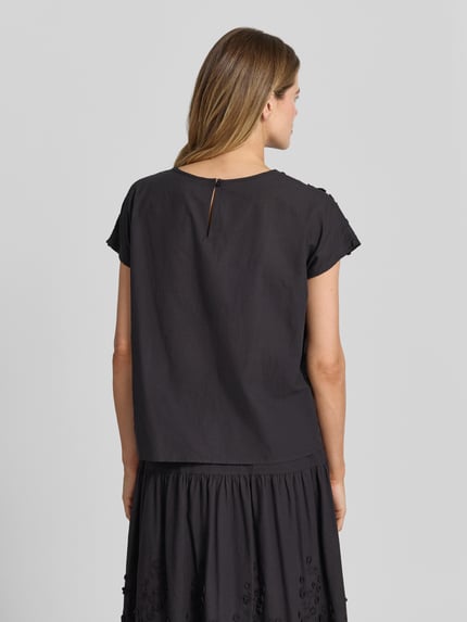 Frauenmodel trägt Regular Fit Bluse mit Rundhalsausschnitt Modell 'FAHIMA' von Soyaconcept aus Reine Baumwolle mit Stitchings, Rückseitiger Knopfverschluss, Rückenlänge bei Größe S 58 cm, Ärmellänge 22 cm, schwarze Farbe, glatte Textur, Ganzkörperansicht Rückansicht.