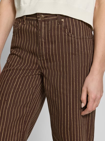 Frauenmodel trägt Straight Fit Jeans im 5-Pocket-Design Modell 'Florchi' von Mango aus Reine Baumwolle mit braun-gelben Streifen, Nahaufnahme Oberkörper.