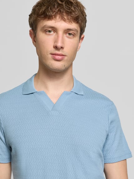 Männermodel trägt Regular Fit Polo-Shirt mit Strukturmuster Modell 'Heskild' von Blend in hellblau, reine Baumwolle, Nahaufnahme Oberkörper.