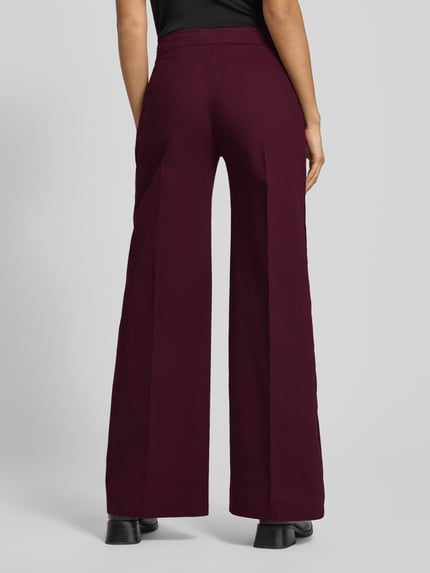 Vrouwenmodel draagt Hose mit elastischem Bund und Eingrifftaschen van Rinascimento, donker bordeauxrood, wijd model, achteraanzicht volledige lengte.
