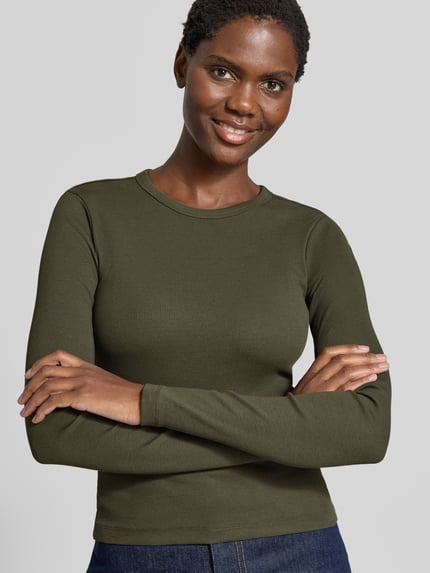Frauenmodel trägt Slim Fit Langarmshirt aus Baumwoll-Mix Modell 'CHLOE' von VERO MODA in Olivgrün, feine Rippstruktur, Nahaufnahme Oberkörper, Damen Langarmshirt von VERO MODA.
