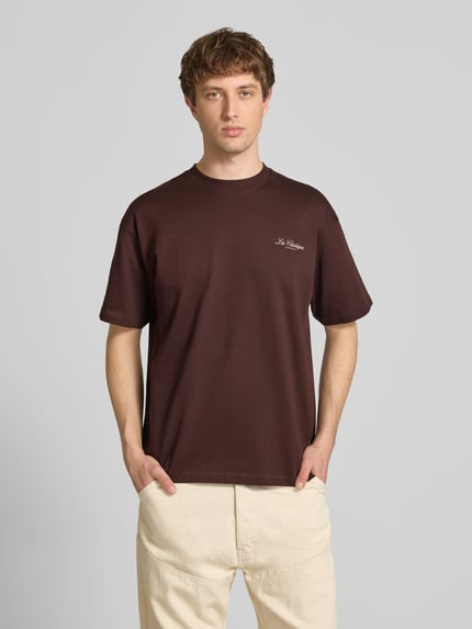 Męski model nosi Loose Fit T-Shirt aus reiner Baumwolle Modell 'LES CLASSIQUES' od Only & Sons, jednolity kolor, jersey, nadruk z napisem, okrągły dekolt, krótki rękaw, optyka: unikolor, krój loose fit. Ganzkörperansicht von vorne.