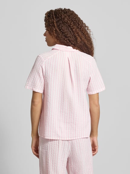 Frauenmodel trägt Regular Fit Hemdbluse aus reiner Baumwolle Modell 'TINNA' von Pieces mit Allover-Muster in Rosa und Weiß, Ganzkörperansicht Rückansicht.