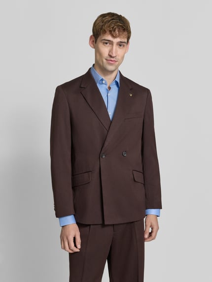 Männermodel trägt Regular Fit Sakko mit Woll-Anteil von Scotch & Soda in Braun, Doppelknopf, Reverskragen, Ganzkörperansicht von vorne, Material-Mix, Pattentaschen und Brusttasche, KI-modifiziertes Bild.