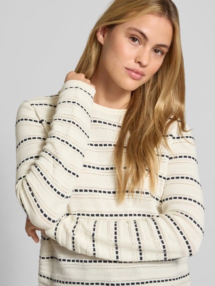 Frauenmodel trägt Regular Fit Longsleeve aus reiner Baumwolle von Christian Berg Woman, creme mit schwarzen Streifen, Strick-Optik, Nahaufnahme Oberkörper.