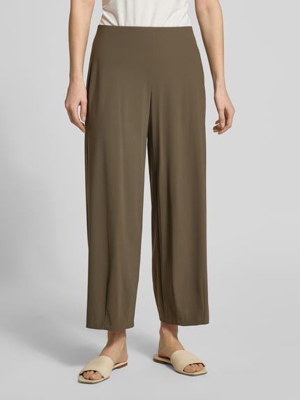 Frauenmodel trägt Relaxed Fit Schlupfhose Modell 'SALLY' von Raffaello Rossi aus High-Tech-Jersey, elastischer Bund, Farbe Braun, Ganzkörperansicht von vorne, Bundweite bei Größe 36: 39 cm, Innenbeinlänge bei Größe 36: 68 cm.