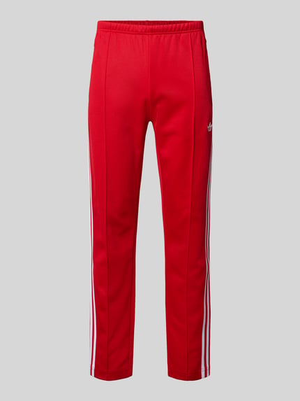 Productfoto, Sweatpants met elastische tailleband van adidas Originals in rood, katoenmix, loose fit, label-stitching, ritszakken, achterzak, binnenbeenlengte maat M 76 cm