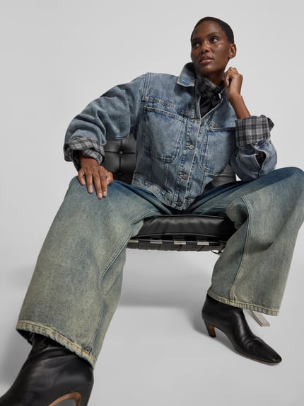 Frauenmodel trägt Funktionsjacke mit Label-Schriftzug Modell 'JEANY' von black palms in medium Wash Denim mit Brusttasche, Nahaufnahme Oberkörper.