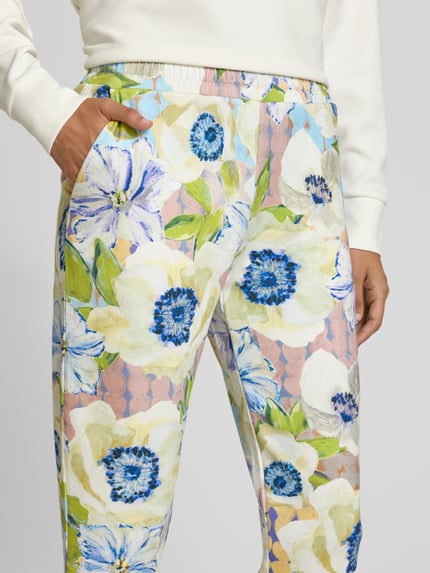 Vrouwenmodel draagt Straight Fit Stoffhose aus Viskose-Mix van Christian Berg Woman met bloemen all-over print, elastische band, verkorte pasvorm, viscosemix. Detailopname heup.