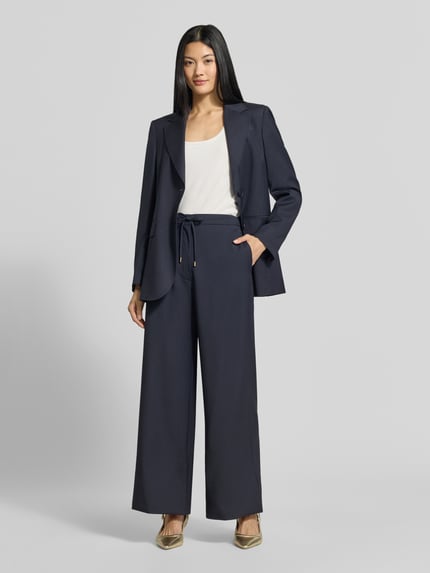 Frauenmodel trägt Regular Fit Longblazer aus reiner Schurwolle Modell 'ASSENZI' von Max Mara Studio in Dunkelblau, Ganzkörperansicht von vorne.