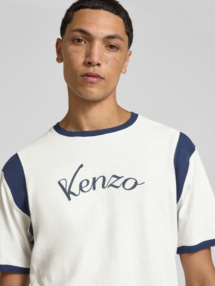Männermodel trägt Regular Fit T-Shirt aus Baumwolle von Kenzo, weiß mit blauen Kontrastpartien, Label-Print, Nahaufnahme Oberkörper.