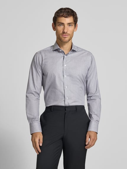 Männermodel trägt Regular Fit Business-Hemd aus Baumwolle von Christian Berg Men mit feinen Streifen, Haifischkragen, Ganzkörperansicht von vorne. Rückenlänge 82 cm, Schulterbreite 42 cm, Ärmellänge 65 cm.