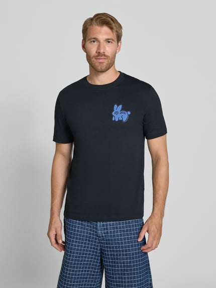Männermodel trägt Regular Fit T-Shirt aus reiner Baumwolle von Paul Smith in Schwarz mit blauem Statement-Print, Nahaufnahme Oberkörper. Herren T-Shirt, Rundhalsausschnitt, Rückenlänge bei Größe M: 64 cm.