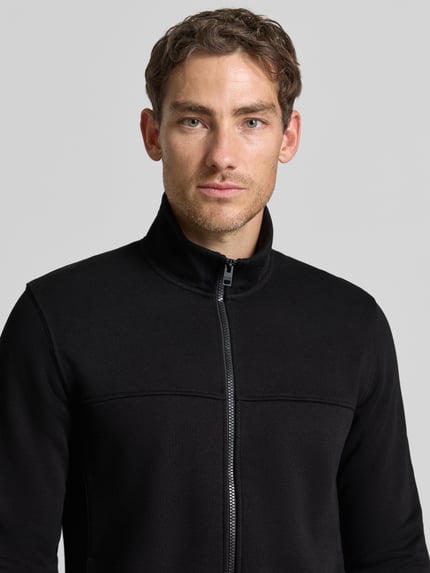 Männermodel trägt schwarze Regular Fit Sweatjacke aus Baumwoll-Mix von s.Oliver RED LABEL, Nahaufnahme Oberkörper.