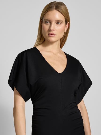 Vrouwenmodel draagt figurbetontes Maxikleid met V-hals Model 'PAMANTI' van Drykorn, lyocellmix met stretch, nauw aansluitend, nahaufnahme bovenlichaam.