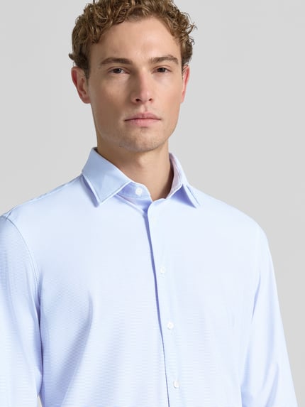 Männermodel trägt Slim Fit Business-Hemd mit Kentkragen von Jake*s aus Material-Mix mit Stretch-Anteil, Knopfleiste, Nahaufnahme Oberkörper. Rückenlänge bei Größe 39/40: 82 cm, Schulterbreite: 42 cm, Ärmellänge: 66 cm.