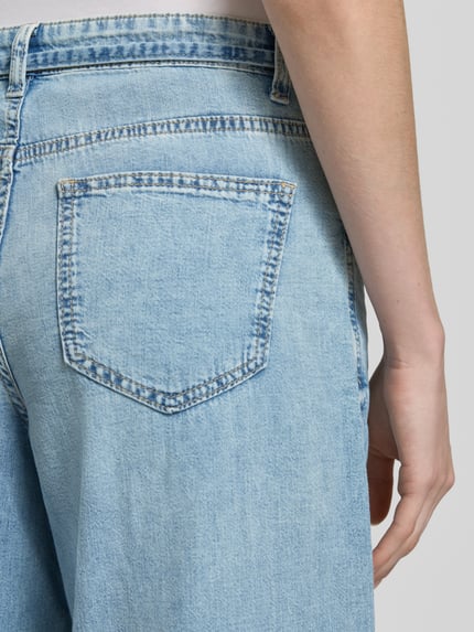 Kobieta nosi Regular Fit Wide Leg Jeans aus reiner Baumwolle Modell 'AISA' od Vero Moda, stylizowana na denim, splot twill, 5 kieszeni, zapięcie na guzik i ukryty zamek błyskawiczny, wykończenie: bawełna, detal szlufek na pasek, zbliżenie na tylne kieszenie, detailaufnahme.