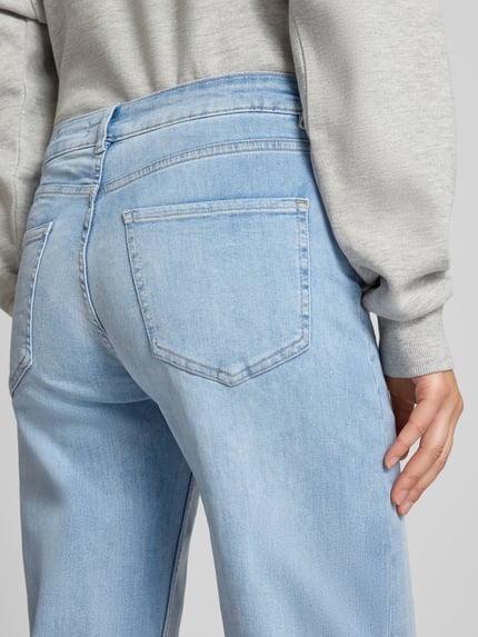 Vrouwenmodel draagt Straight Fit Jeans uit katoenmix van review, lichtblauw met 5-pocketmodel, knoop- en ritssluiting, detailopname rugzijde. Context: dames jeans van REVIEW, elastische katoenmix, straight fit, 5-pocketmodel, knoop- en ritssluiting, bandwijdte bij maat 27: 37 cm, binnenbeenlengte bij maat 27: 77 cm.