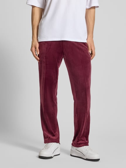 Männermodel trägt Sweatpants mit elastischem Bund von SERGIO TACCHINI in Bordeaux, Material-Mix mit Stretch-Anteil, lockerer Schnitt, Ganzkörperansicht von vorne.