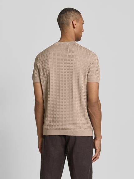 Männermodel trägt T-Shirt mit Label-Detail Modell 'Theor' von JOOP! Collection in Beige, strukturierte Textur, Rückenansicht, Ganzkörperansicht Rückansicht.