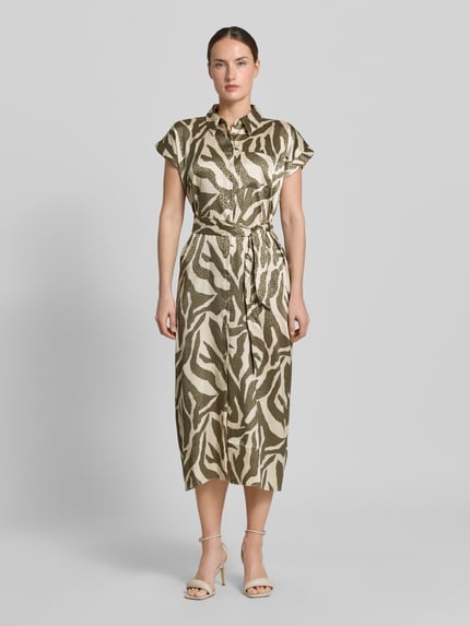 Vrouwenmodel draagt Hemdblusenkleid mit Brusttasche und Bindegürtel van Apricot, materiaalmix met stretch, getailleerd model, midi-jurk, knoopsluiting, borstzak, strikceintuur, ruglengte maat S 41 cm, borstwijdte maat S 44 cm, mouwlengte maat S 3 cm, lichtbruine en beige tinten, animalprint, gladde textuur, ganzekörperaanzicht van voren.