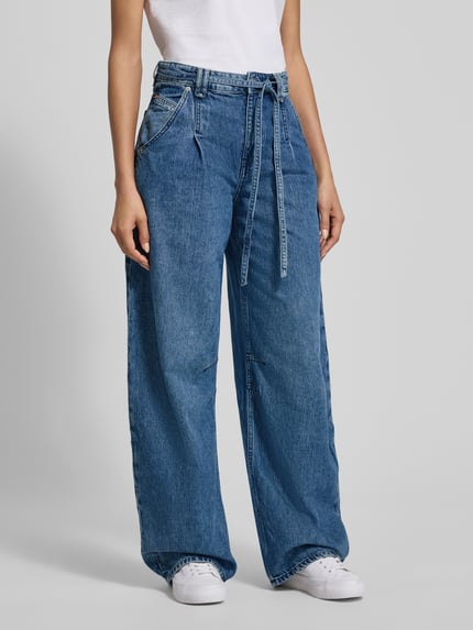 Kobiece modelka nosi spodnie z szerokimi nogawkami Wide Leg Jeans aus Baumwoll-Lyocell-Mix Modell 'C_PLEATED BARREL 1.0' od BOSS Orange, stylizowane na denim, krój wide fit, naszywka z logo, nity, zakładka w pasie, szlufki na pasek, zapięcie na guzik i ukryty zamek, wiązany pasek, wpuszczane kieszenie z boku, kieszenie z tyłu, mieszanka bawełny i lyocellu, widok całej sylwetki z przodu.