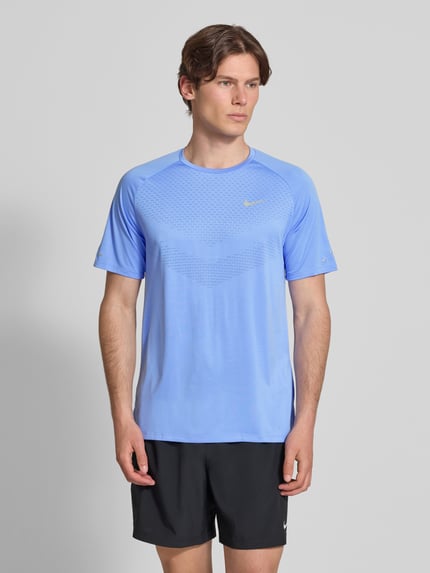 Männermodel trägt Funktionsshirt mit Logo und Rundhalsausschnitt Modell 'Stride' von NIKE TRAINING in Blau, Regular-Fit, Ganzkörperansicht von vorne, Rückenlänge bei Größe M 73 cm.