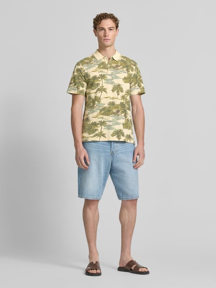 Männermodel trägt Regular Fit Poloshirt mit floralem Allover-Print Modell 'Hawaii' von JACK & JONES Premium aus Reine Baumwolle, Ganzkörperansicht von vorne.