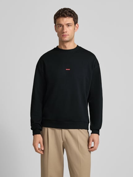 Männermodel trägt Regular Fit Sweatshirt aus reiner Baumwolle Modell 'DUBRAXO' von HUGO, Optik: Unifarben, Ganzkörperansicht von vorne.