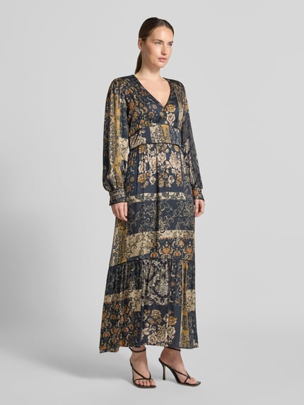 Frauenmodel trägt Maxikleid aus reiner Viskose von Liu Jo White mit floralen Prints in Blau und Beige, taillierte Passform, V-Ausschnitt, Ballonärmel, Ganzkörperansicht von vorne.