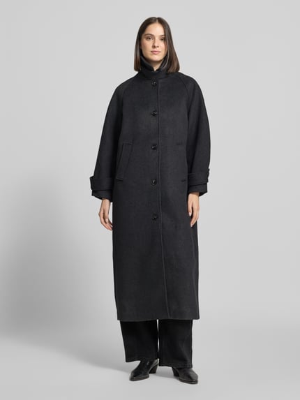 Frauenmodel trägt Mantel aus Leinen-Mix mit Stehkragen Modell 'Keaton' von Neo Noir, schwarz, Knopfleiste, Regular Fit, Ganzkörperansicht von vorne.
