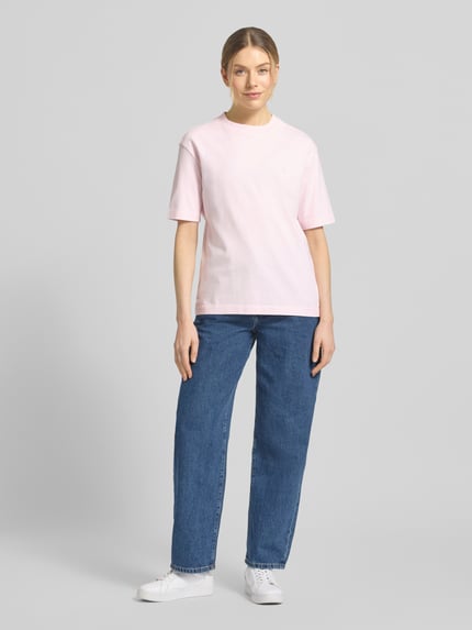 Frauenmodel trägt Loose Fit T-Shirt aus reiner Baumwolle Modell 'TARJAA' von Armedangels, unifarben, Kurzarm, Feinripp, Ganzkörperansicht von vorne.