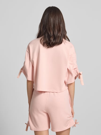 Frauenmodel trägt Boxy Fit Pyjama-Oberteil mit Baumwoll-Anteil von HUGO in Optik: Unifarben, Sweat-Material, Cropped-Länge, Rückansicht.