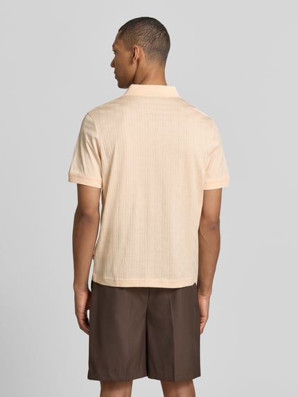 Męski model nosi Modern Fit Poloshirt mit Strukturmuster Modell 'Roberto' od JOOP! Collection, bawełna, polokrąg, detal z logo, widok całej sylwetki z tyłu.