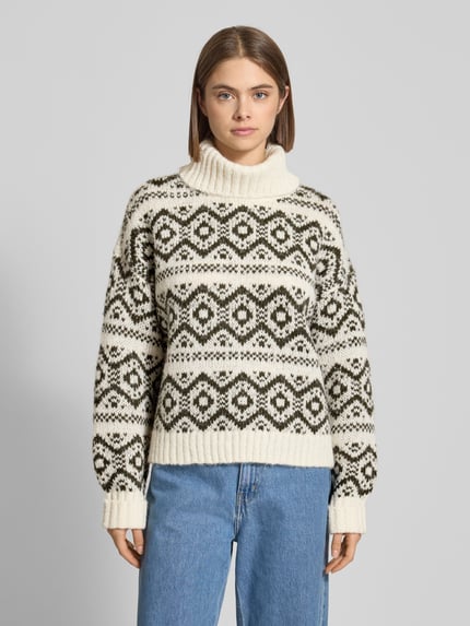Frauenmodel trägt Regula Fit Rollkragenpullover mit Allover-Muster Modell 'CARIN' von Only im Norwegen Muster, Strick, creme und schwarz, gerippte Abschlüsse, Ganzkörperansicht von vorne.